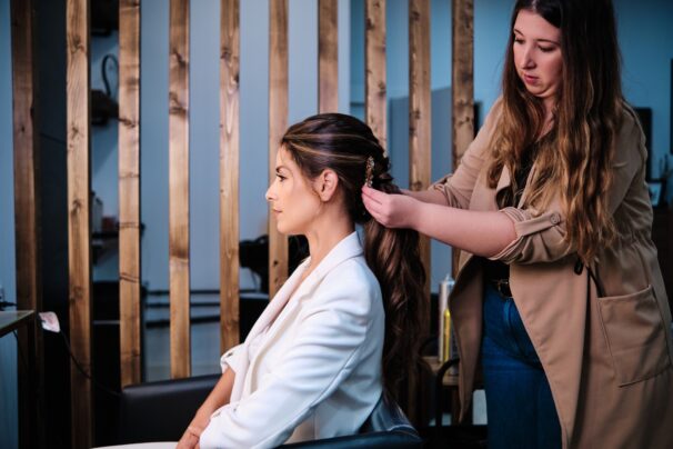 Hairstylist doing a hairstyle for a bride for her wedding day at the hair salon.